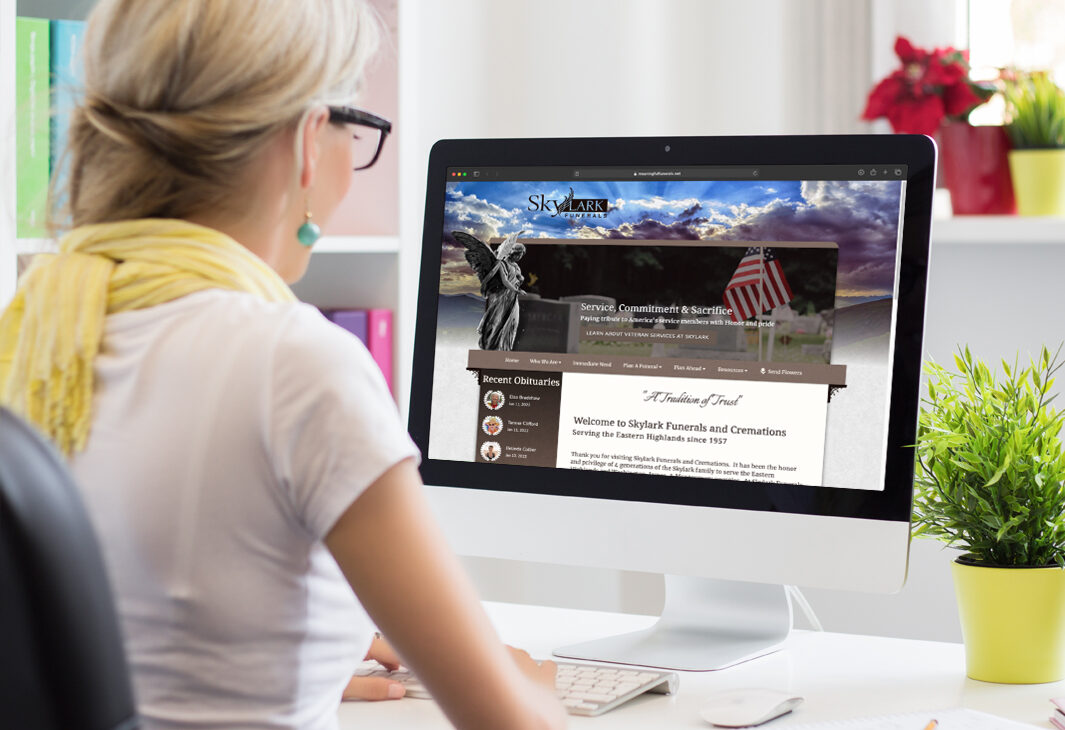 Female looking at custom obituary website on computer